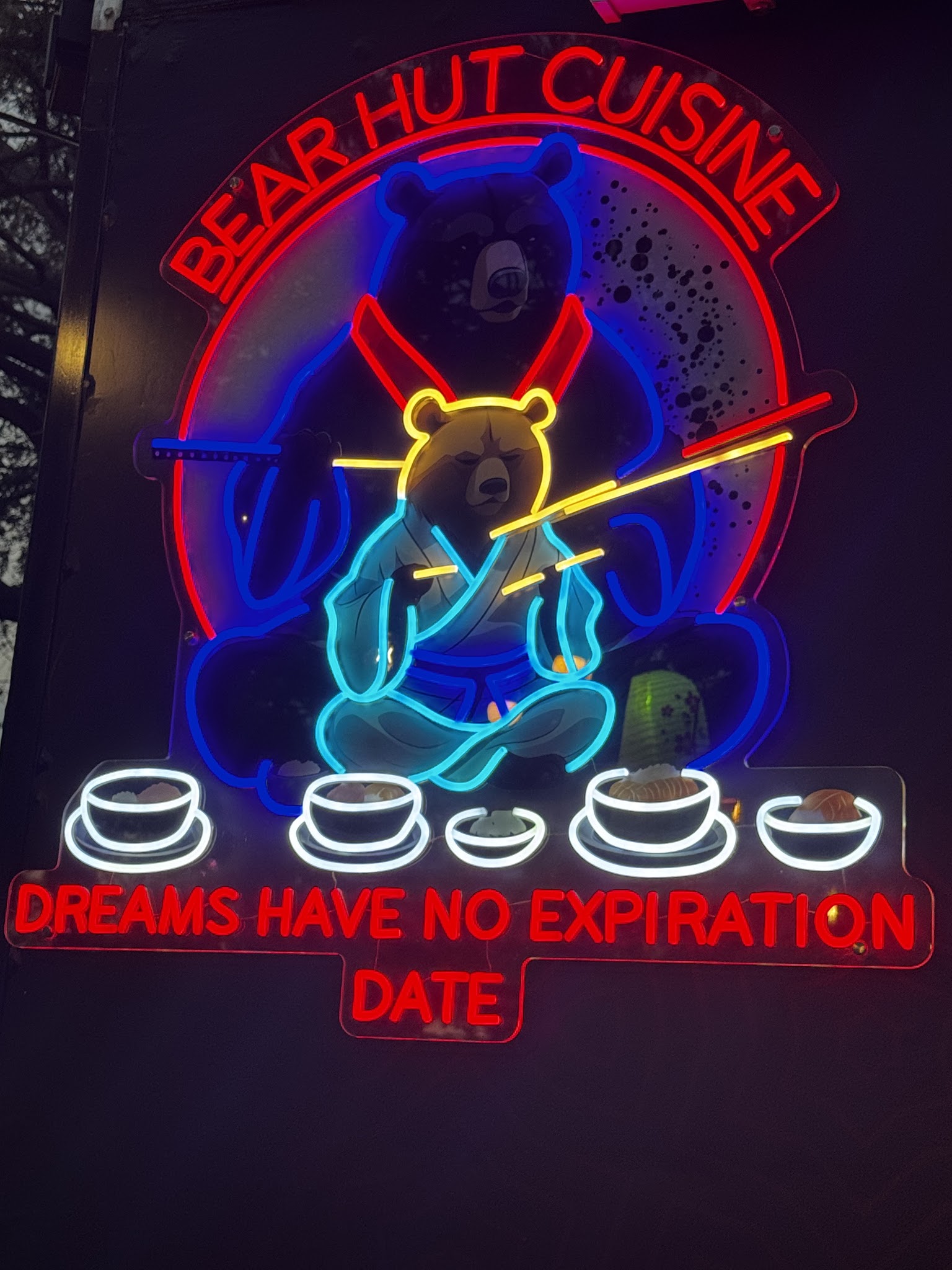 Bear Hut Cuisine neon sign with its bear mascot.