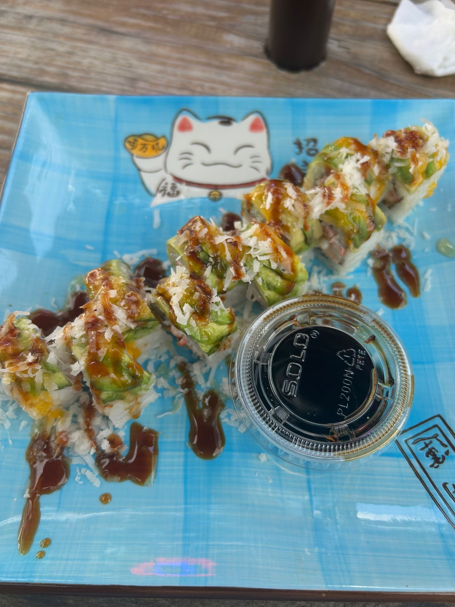 Sushi rolls on a blue plate with soy sauce.