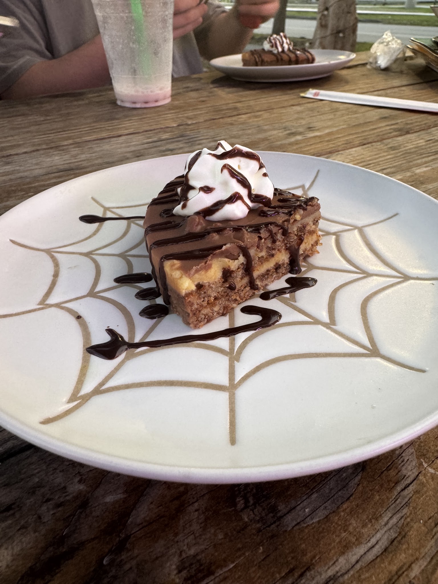 Chocolate dessert topped with whipped cream and chocolate drizzle.
